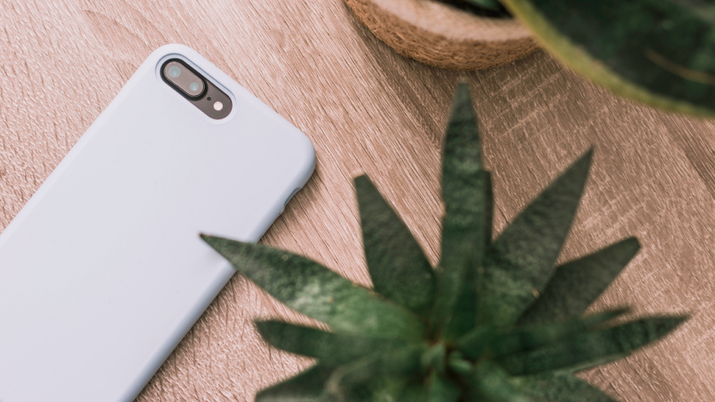 Phone upside down on a table with a houseplant