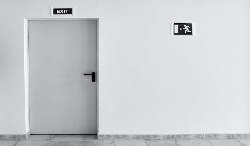 A grey tone wall and door with exit signs