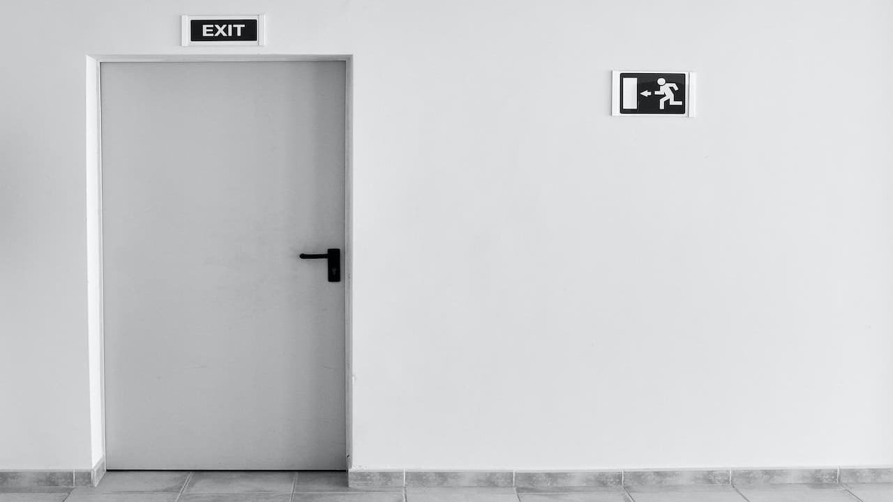 A grey tone wall and door with exit signs